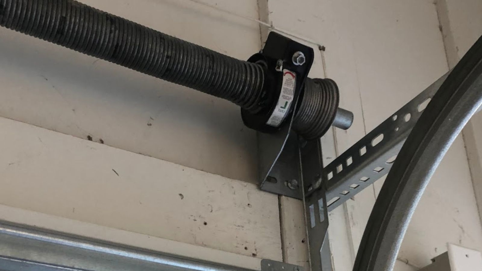 A cable coiled in its drum on the garage door