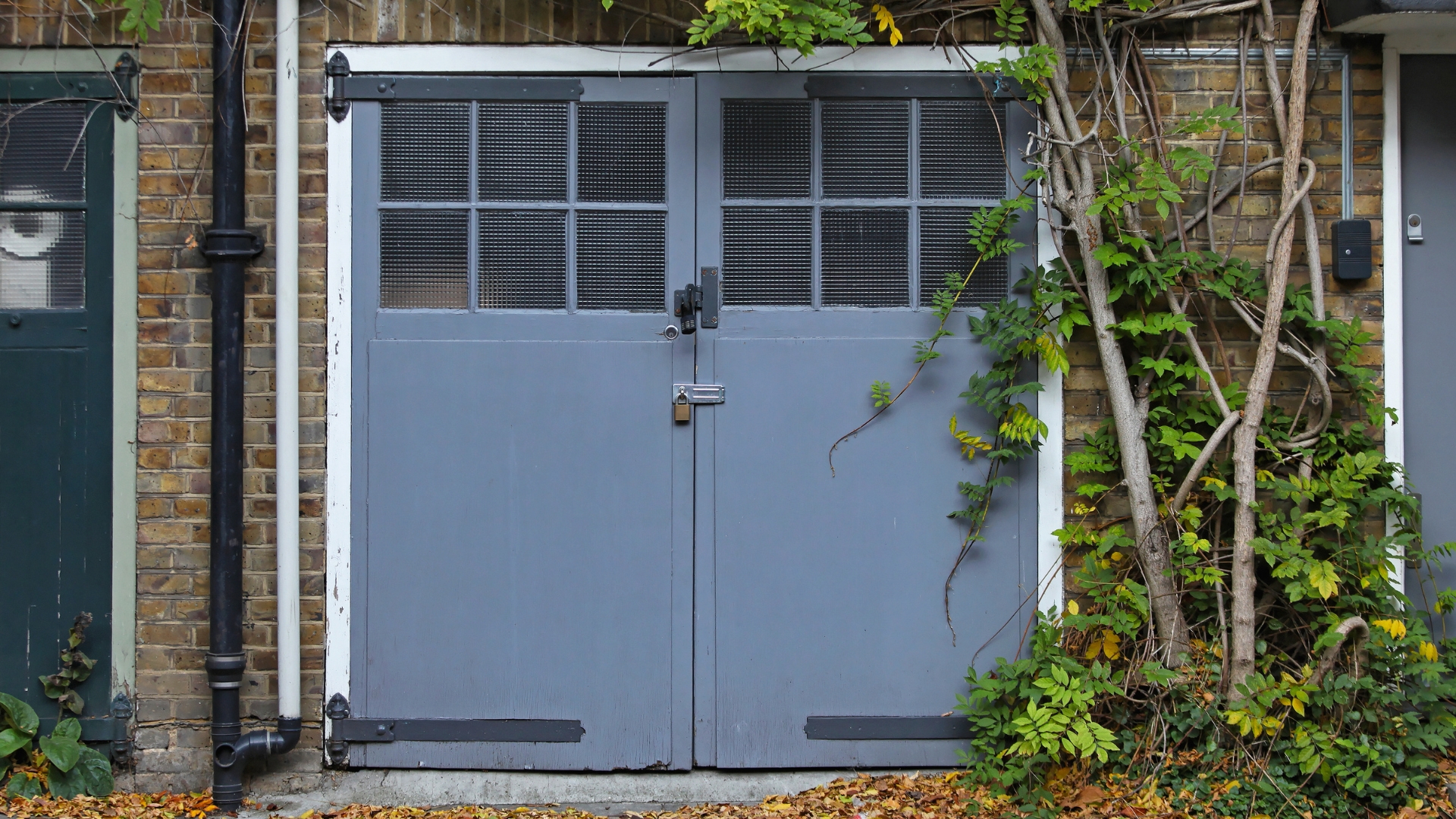 An old-style residential garage door with side hinges