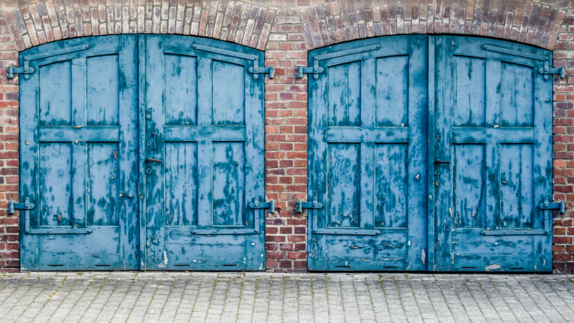 Two carriage-style garage doors with decorative hardware