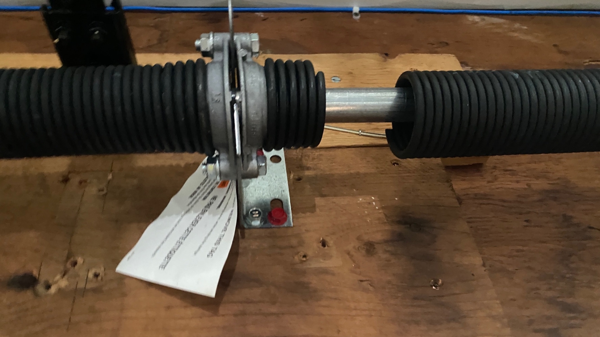 A close-up of a broken spring on a garage door system.