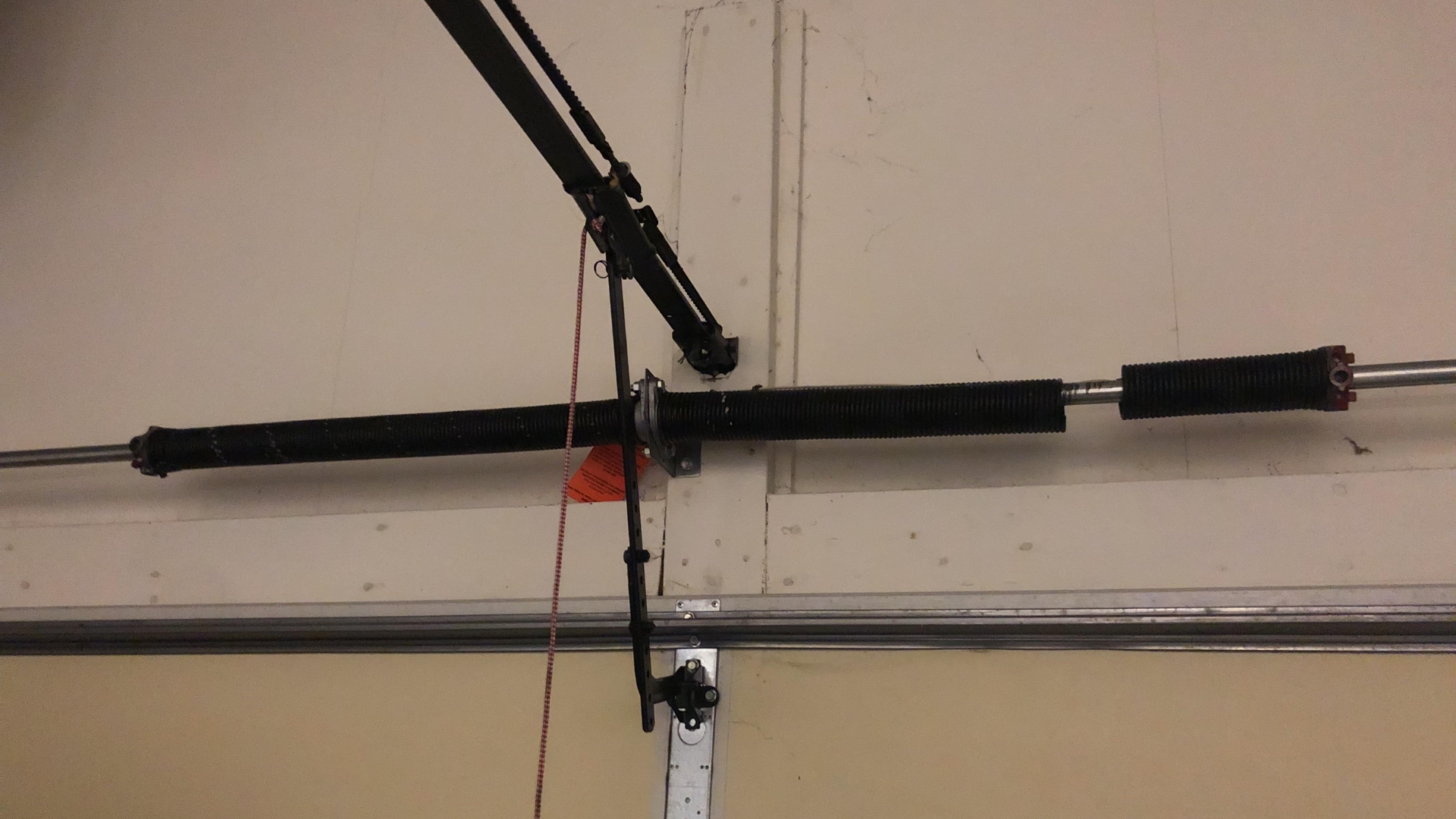 Broken garage door torsion spring with visible gap — sign of spring failure requiring repair